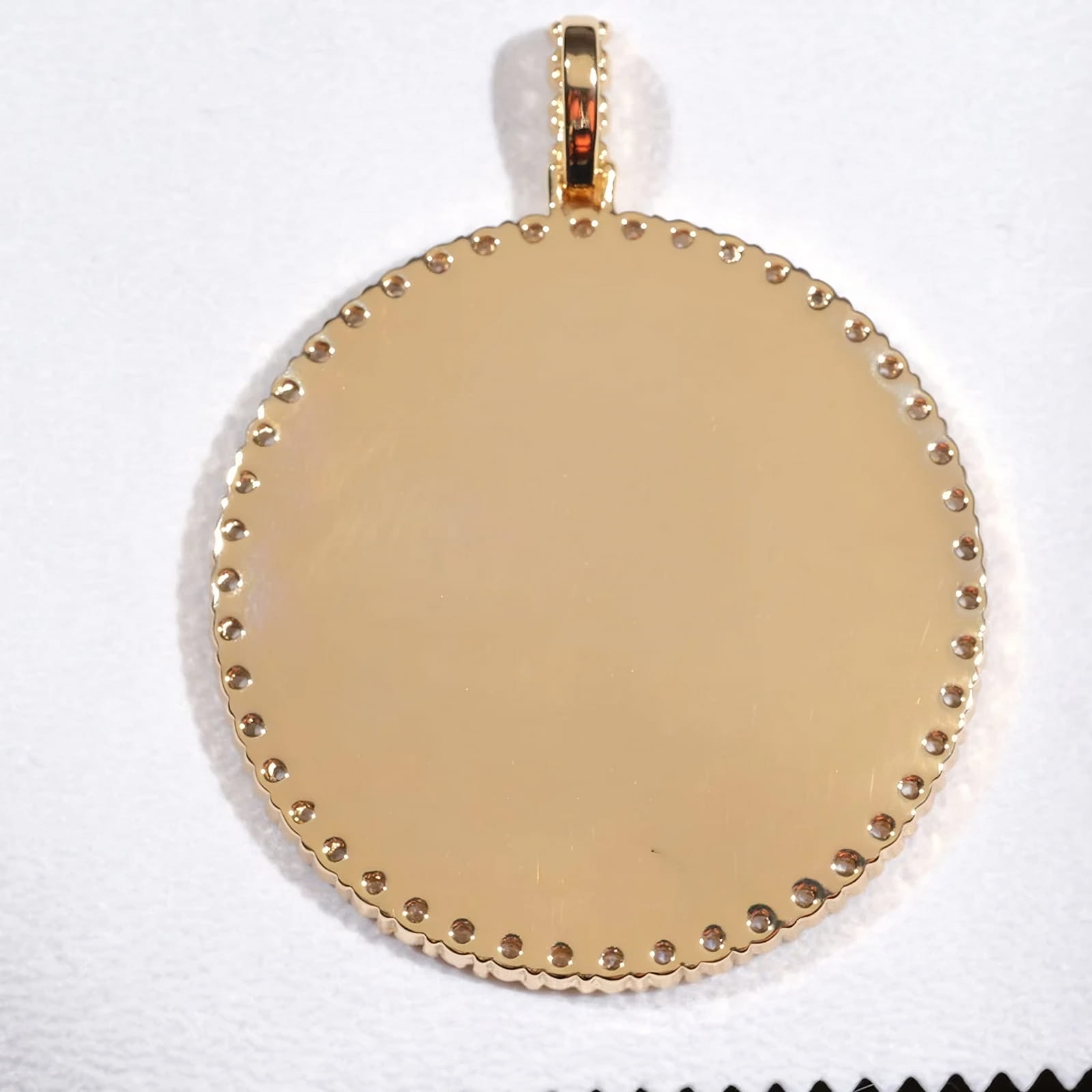 Backside view of round pendant with polished gold finish