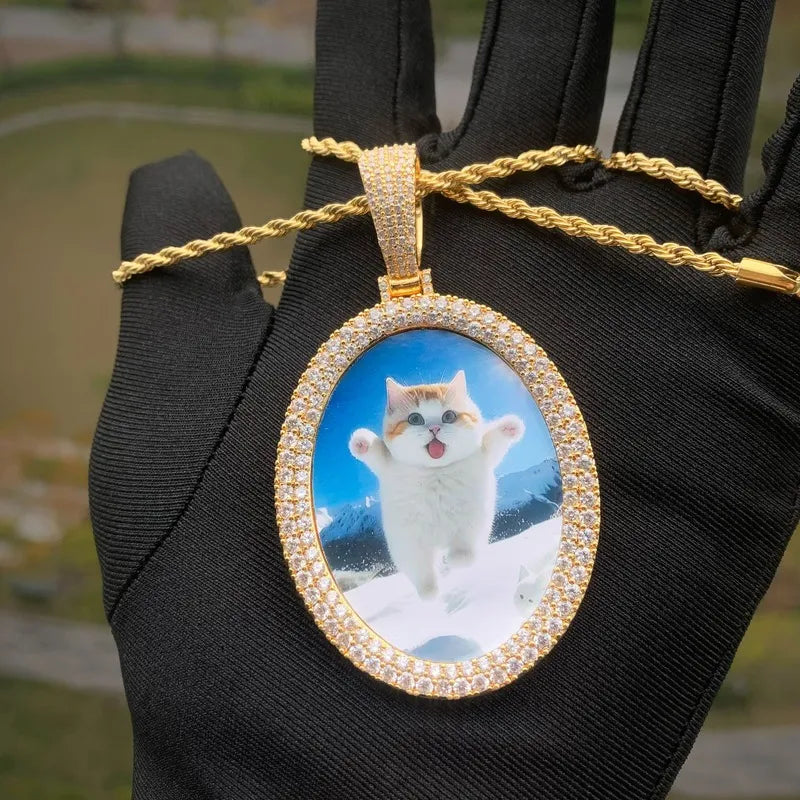 Oval custom photo pendant shown in hand with gold chain for size reference