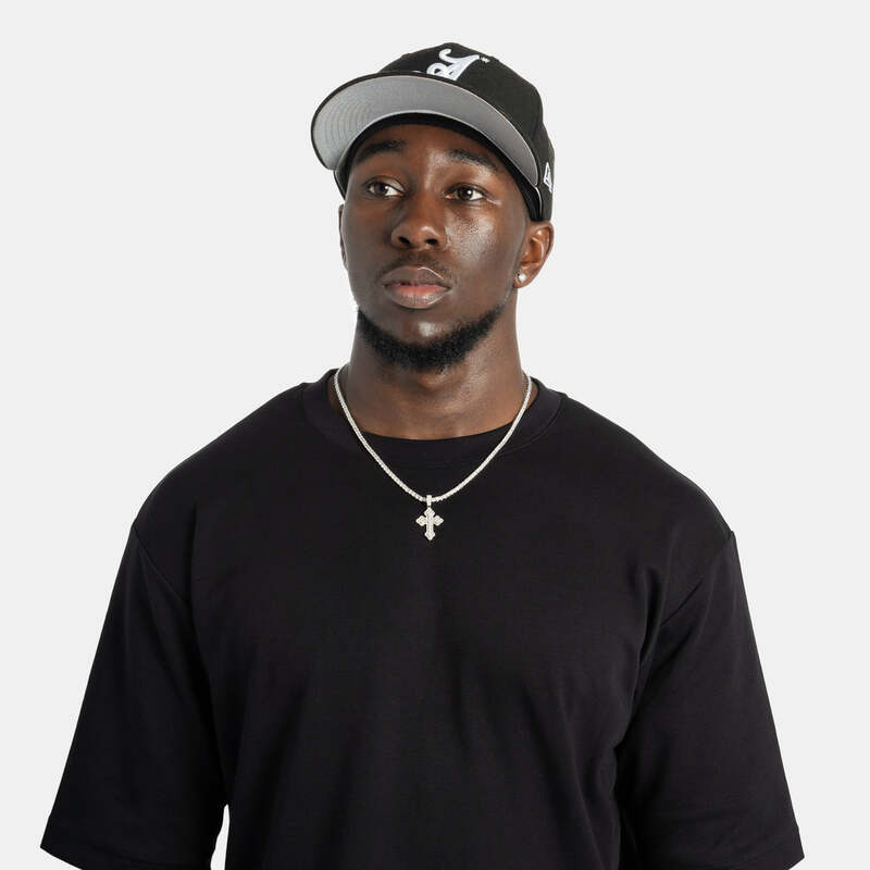 Iced micro cross pendant necklace in white gold worn on model
