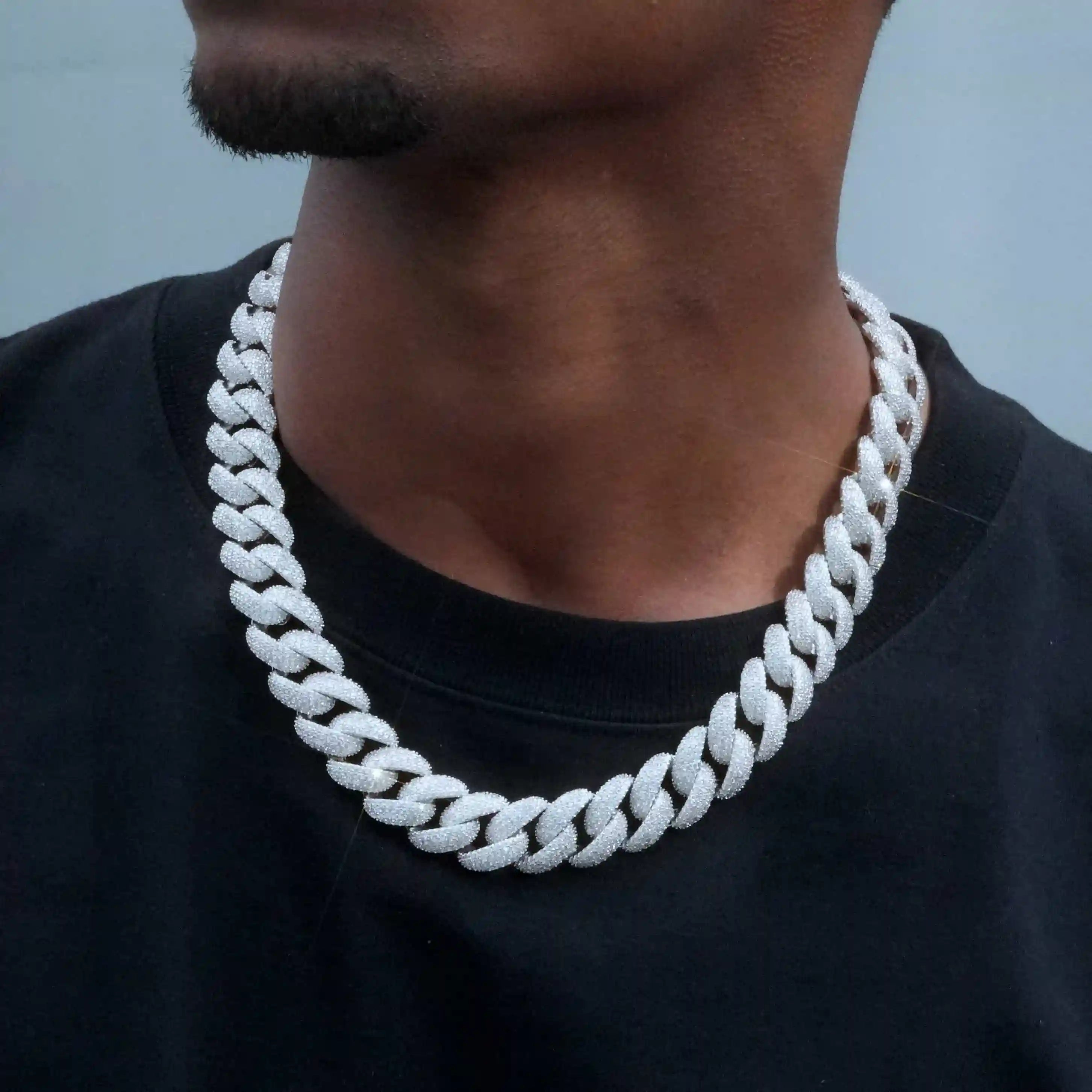 Introducing our new 18mm Curved Clasp Bubble Cuban Link Chain featuring VVS simulated diamonds to ensure perfect clarity at an affordable price. This handcrafted chain shines from all angles and makes a bold statement. Available in 18, 20, and 22 inches with a white gold finish, flawless VVS simulated diamonds, and a custom designed link. Package includes chain, dust bag, gift box, jewelry cloth, and warranty card.