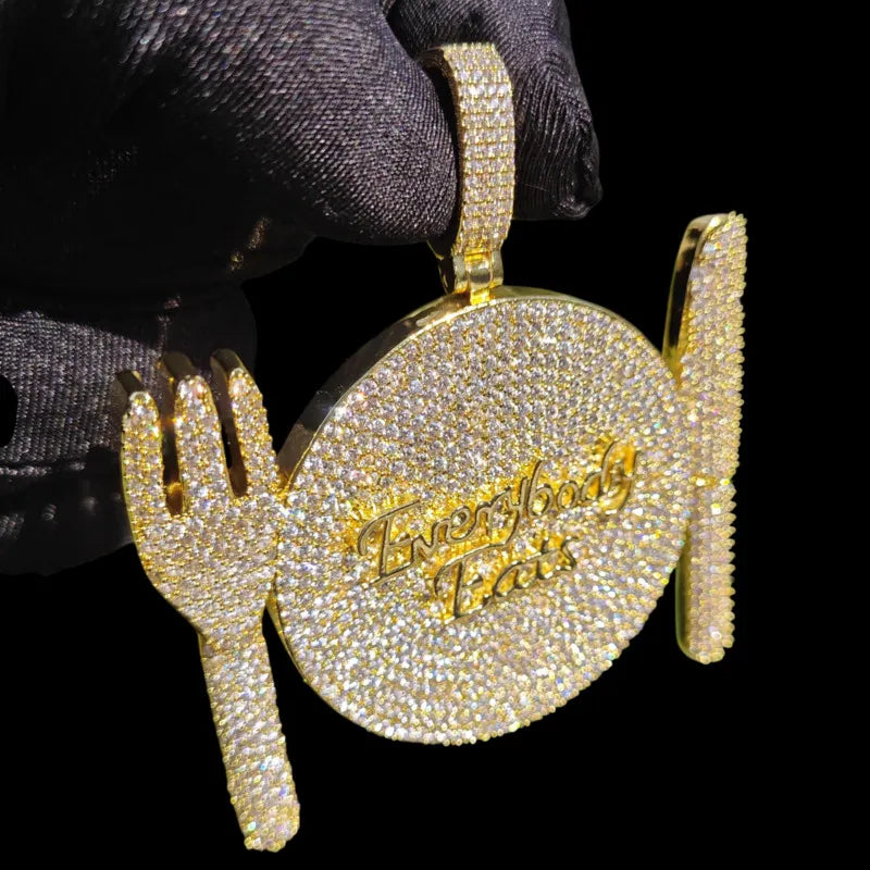 Close-up gold dinner plate pendant with fork and knife design, iced out hip hop necklace detail