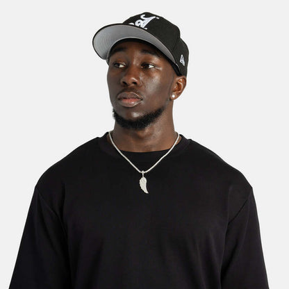 Model wearing iced wing pendant necklace in white gold