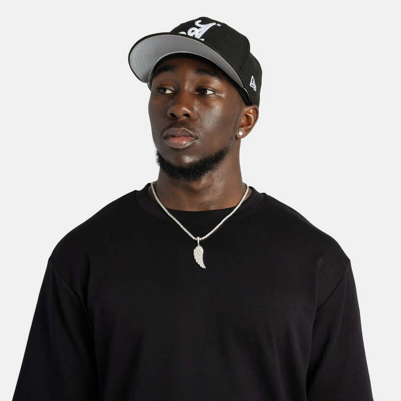 Model wearing iced wing pendant necklace in white gold