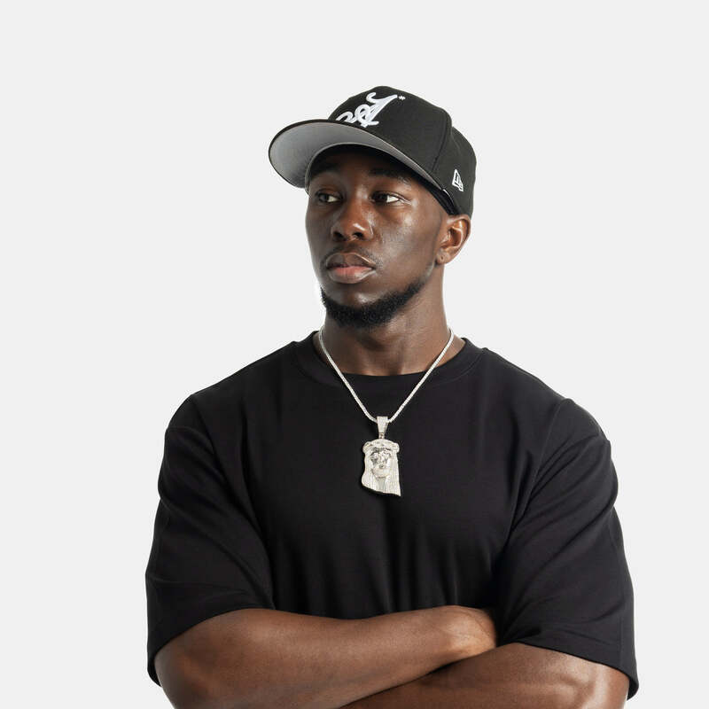 Man wearing large iced Jesus pendant necklace in yellow gold, hip hop jewelry style